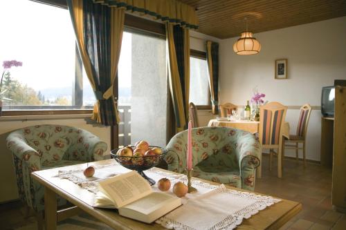 蒂罗尔-泽费尔德Haus Wandl的一间房间,配有一张桌子,放着一碗水果和一本书
