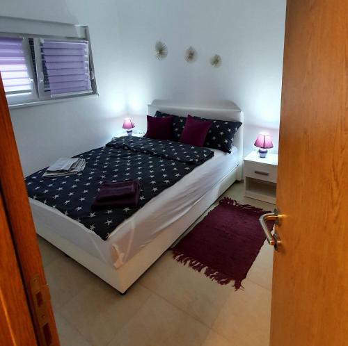 维尔蒂尼克Lux Snezana的一间卧室配有一张带紫色枕头的床
