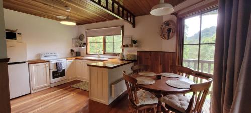阿波罗湾Tall Trees Eco Retreat的厨房配有木桌和桌椅