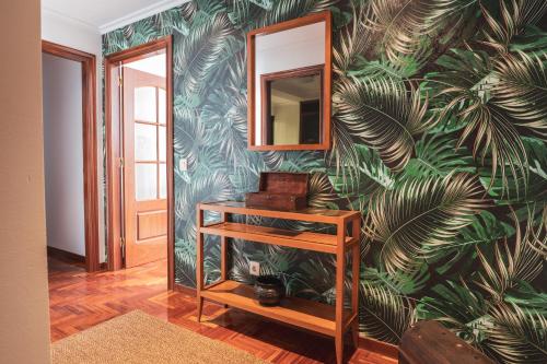 维戈Apartmento Alcabre (Vigo) vistas al mar 6 personas的一间有一面墙壁的树叶壁画的房间