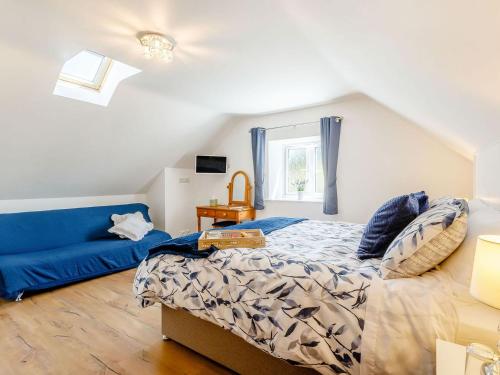 IlchesterPea Cottage的一间卧室配有一张床和一张蓝色的沙发