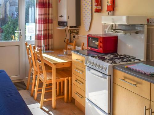 波斯科诺16 Beech Cottage-uk38936的厨房配有炉灶和带微波炉的桌子。