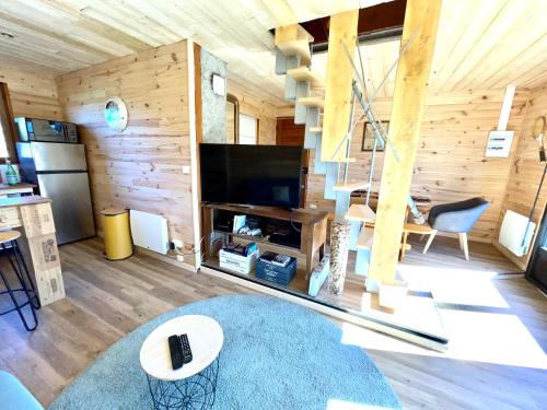 沙斯特雷La cabane au pied des pistes的客厅设有木墙和大电视