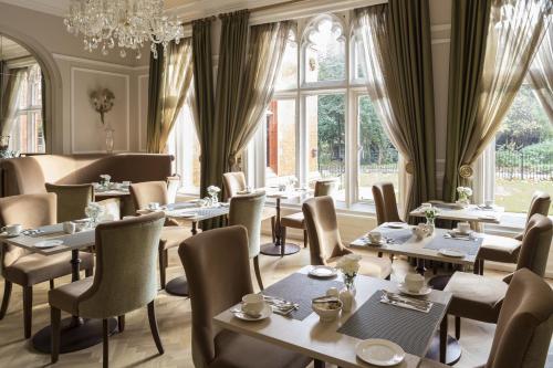 伦敦圣保罗酒店的一间带桌椅和吊灯的餐厅