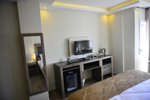 瓦迪穆萨Moses Residence的一间卧室配有电视、一张床和镜子