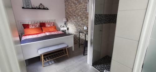 TannenbergFerienwohnung Tannenzwerg的一间小卧室,配有带橙色枕头的床