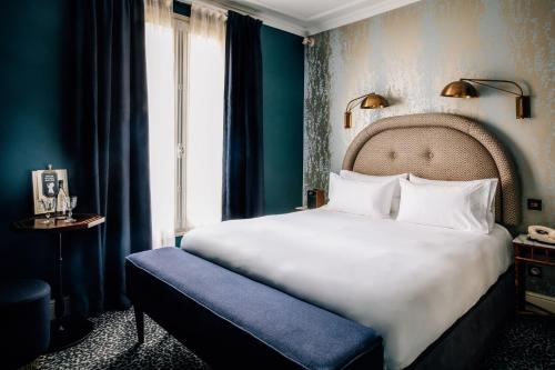 巴黎皮嘉尔大酒店的卧室设有一张白色大床和一扇窗户。
