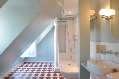 巴黎皮嘉尔大酒店的浴室配有卫生间、盥洗盆和淋浴。