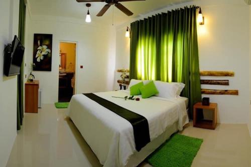 古雷德胡Rangali Etos Guraidhoo的一间卧室配有一张带绿帘的大床