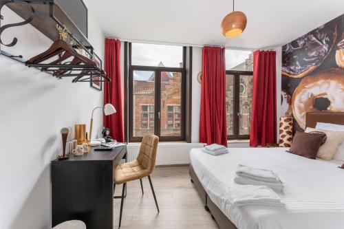 布鲁日The Chocolate Suites的一间卧室配有一张床、一张书桌和红色窗帘