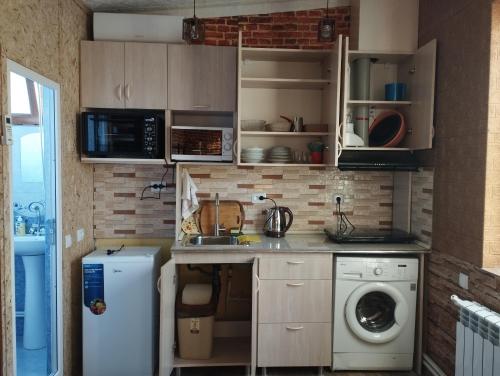 埃里温COZY HOTEL SKS的小厨房配有洗衣机和微波炉