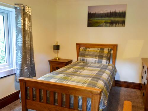 MundfordTree Tops Cottage的一间卧室设有一张床和一个窗口