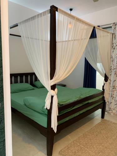 曼德姆Coastal Soul的一间卧室配有带窗帘的天蓬床