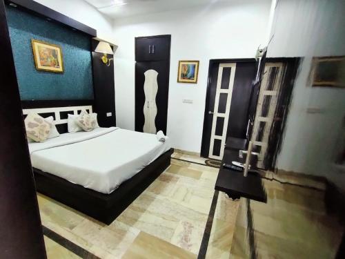 阿格拉Hotel Laxman Resort by The Golden Taj Group &Hotels的一间设有床铺的房间和一张三脚架上的摄像头