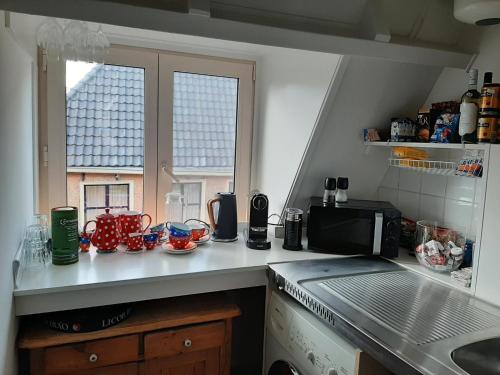 吕伐登Logement het Herenwaltje的带微波炉的厨房台面和窗户