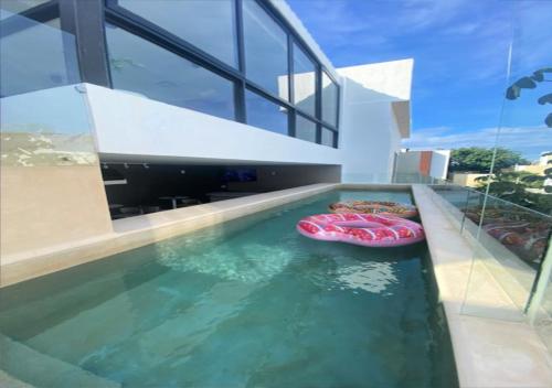 普拉亚卡门Auténtico Vertical Playa del Carmen的一座房子里有两个充气池的游泳池