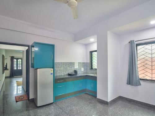 卡兰古特Calangute Beach Corner的厨房配有蓝色橱柜和蓝色冰箱