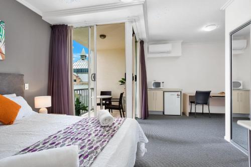 凯恩斯City Quays Accommodation的酒店客房设有一张床和一个阳台。