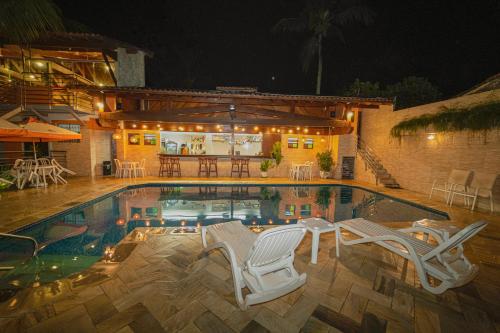 坎布里卡姆布里普拉亚酒店的一个带两把椅子的游泳池以及一座房子