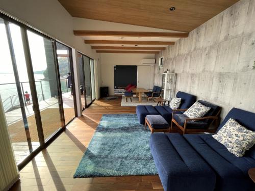 尾道市Côte terrasse onomichi - Vacation STAY 92432v的客厅配有蓝色的沙发和桌子