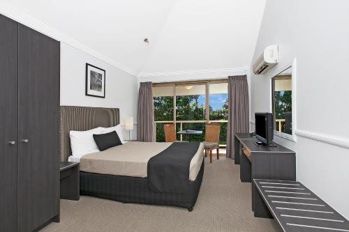 布里斯班Comfort Inn & Apartments Northgate Airport的一间卧室配有一张床、一台电视和一张书桌