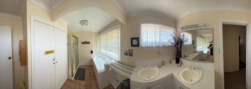 布里斯班Rose'n Daves Guest House的一间带两个盥洗盆和大镜子的浴室