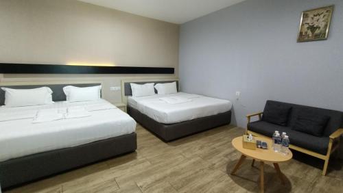 哥打京那巴鲁Unikarya Lodge的酒店客房,设有两张床和一张沙发