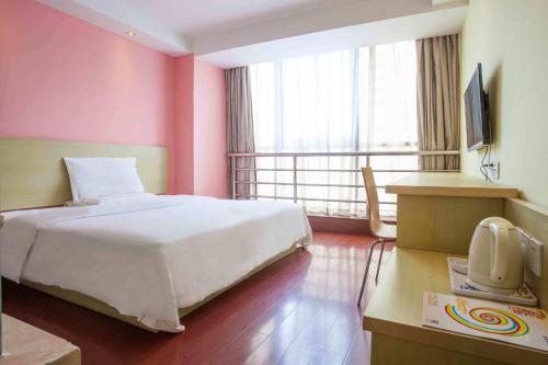 韶关7天连锁酒店韶关步行街店的卧室配有白色的床和粉红色的墙壁