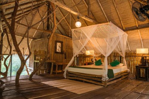 蒂瑟默哈拉默The Saraii Tree Lodge的一间带一张床的卧室,位于带木制天花板的房间内