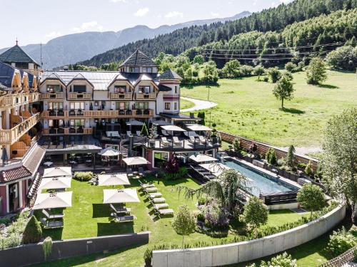科姆梅扎杜拉Tevini Dolomites Charming Hotel的享有带游泳池的度假村的空中景致