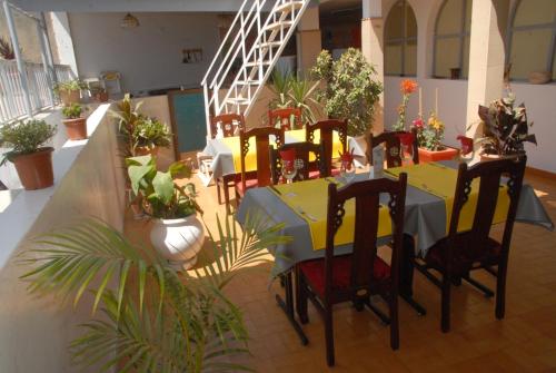 达喀尔奥帕诺拉米奇旅馆的用餐室配有桌椅和植物