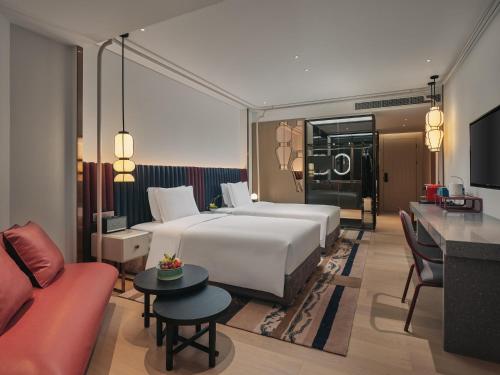 杭州杭州上城英迪格酒店（近西湖，钱塘江畔，设计师酒店，入住尊享首轮minibar欢饮礼遇）的酒店客房设有一张大床和一张沙发。