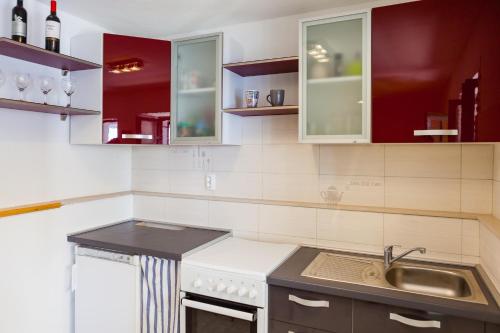 布拉托The Captain's Nook Spiliska的一间带红色橱柜和水槽的厨房