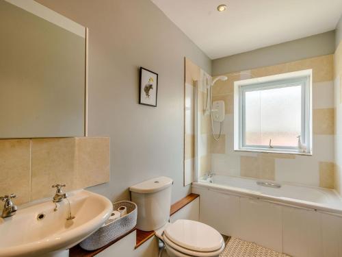 罗森代尔Courtyard Cottage - Uk39179的浴室配有卫生间、盥洗盆和浴缸。