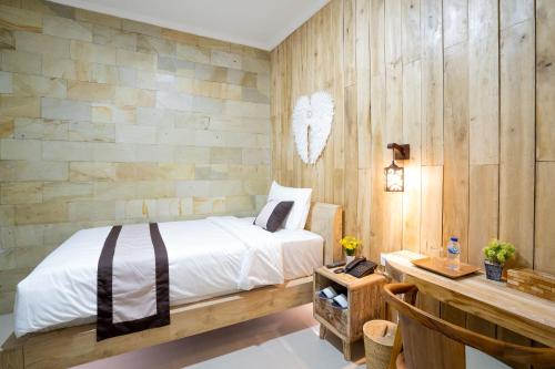 库塔Oki Taru Residence的一间卧室设有一张床和木墙