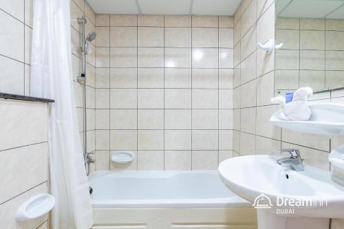 迪拜Dream Inn Apartments - Marina Pinnacle的带浴缸、水槽和淋浴的浴室