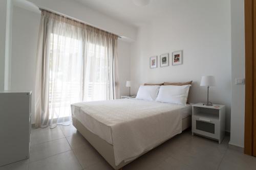 弗尔卡Aetofolia Stella Villas的白色的卧室设有一张大床和一个窗户