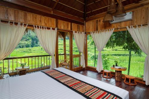 Pu LuongPuluong Luna Resort的一间带一张大床的卧室,位于带窗户的房间内