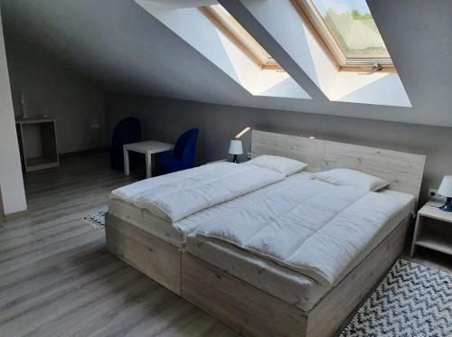 MrozyStajnia Kruki的一间带一张大床的卧室,位于带天窗的房间