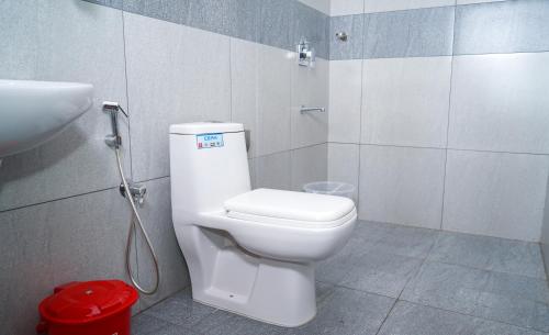 科泽科德Atmos Inn的浴室配有白色卫生间和盥洗盆。