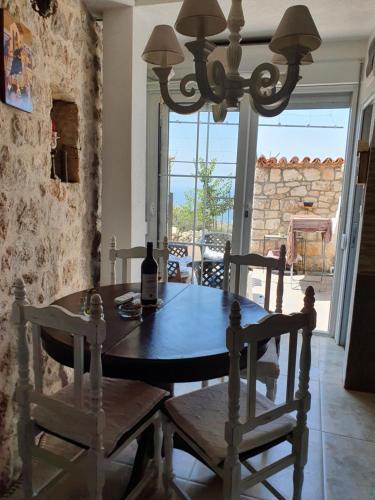 布德瓦Stone house Djakonovic的用餐室配有带1瓶葡萄酒的桌子