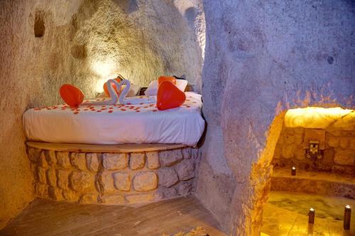 内夫谢希尔Saliche Cave Suite的洞穴内的卧室,配有一张床和浴缸