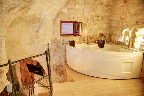 内夫谢希尔Saliche Cave Suite的石墙客房内的浴缸