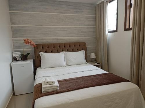 波梅罗迪Pousada Harmonia Pomerana的一间卧室配有一张大床和两条毛巾