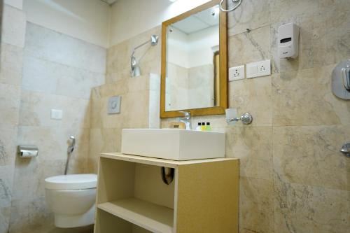 甘托克Mann Dechen and Palmo, Mg Marg, Gangtok的一间带水槽、卫生间和镜子的浴室