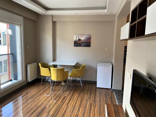 伊斯坦布尔Ninve Apartments – Istanbul Bakirköy的一间带桌子和黄色椅子的用餐室