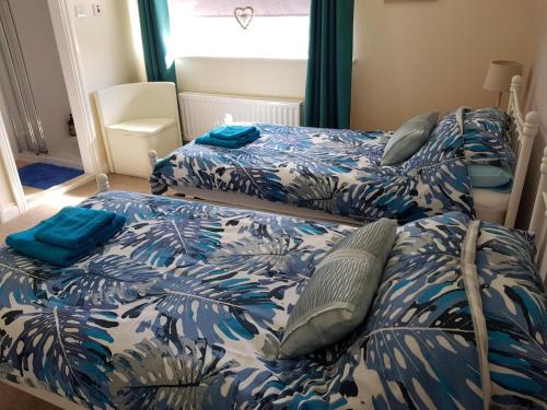 杜伦班克罗夫特公寓的卧室内的两张床,配有蓝色和白色的床单