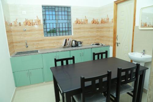 蒂鲁帕蒂Ameya Homestays Brand New Fully Furnished 3BHK & 2BHK Apartments.的厨房配有黑色桌子和水槽