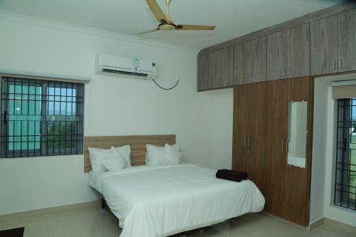 蒂鲁帕蒂Ameya Homestays Brand New Fully Furnished 3BHK & 2BHK Apartments.的卧室配有白色的床和天花板