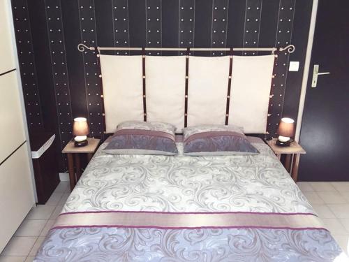 MarsillarguesChambre d'hôte " Le Ponant "的一间卧室配有一张带2个床头柜的大床